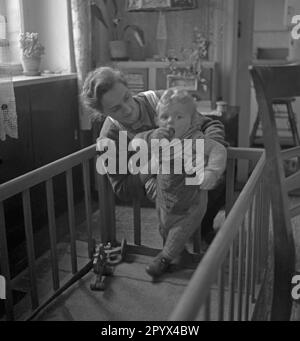 Photo non datée d'une grand-mère jouant avec son petit-enfant dans un parc dans un appartement, probablement à Berlin-Ouest, 1950. Enfant d'un soldat allemand tué au cours de la Seconde Guerre mondiale, l'enfant est à moitié orphelin. Banque D'Images