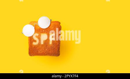 Concept de crème SPF sur pain grillé. Arrière-plan jaune. Banque D'Images