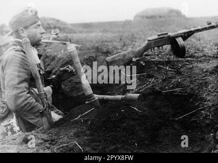 Un fantassin allemand en position près de Poltava, dans la partie sud du front oriental. Sur la pente de la tranchée en face de lui se trouve une arme russe pillée, un canon de sous-machine PPSch-41 (Schpadin). Photo: Rebhan. [traduction automatique] Banque D'Images