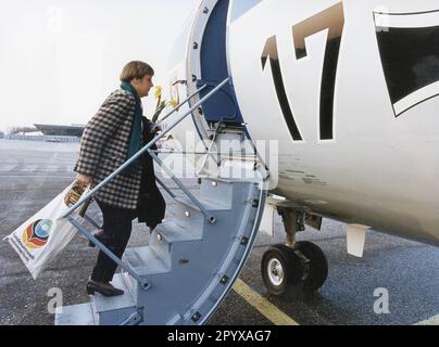 La ministre de l'Environnement Angela Merkel (CDU) est montée à bord de l'avion avec un sac du ministère fédéral de l'Environnement, un pot de miel et un bouquet de jonquilles dans sa main. [traduction automatique] Banque D'Images