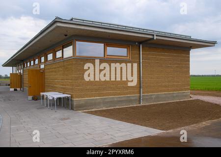 05 mai 2023, Saxe-Anhalt, Pömmelte-Zackmünde: Vue sur le 'Centre d'information touristique du Sanctuaire de l'anneau de Pömmelte'. Le bâtiment est la première structure moderne de terre rammed dans le centre de l'Allemagne. Pour le centre d'accueil, environ 130 tonnes d'argile ont été estampillées couche par couche à la main. Le bâtiment mesure 25 mètres de long, 5 mètres de large et 3,60 mètres de haut. Photo: Klaus-Dietmar Gabbert/dpa/ZB Banque D'Images