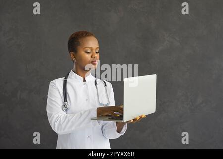 Une jeune femme afro-américaine travaille sur un ordinateur portable en ligne Banque D'Images