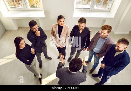 Groupe de jeunes professionnels en entreprise se tenant ensemble et communiquant Banque D'Images