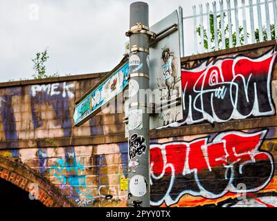 Un pont Canal Bridge couvert de graffiti à Manchester, Salford présente l'art de la rue dynamique de cette zone urbaine et sa communication par le texte. Banque D'Images