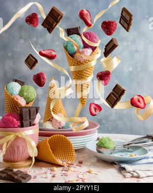 Un assortiment de cônes de crème glacée remplis de bonbons et de fraises Banque D'Images