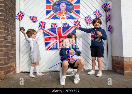 Halesowen, West Midlands, Royaume-Uni. 5th mai 2023. Quatre jeunes frères excités devant la porte de garage de leur famille, décorés prêts pour le couronnement du roi Charles III à Halesowen, West Midlands. Crédit : Peter Lophan/Alay Live News Banque D'Images