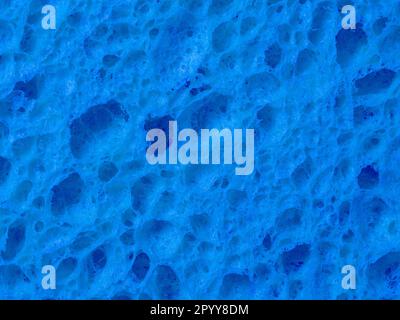 La texture rugueuse d'une éponge bleue pour lave-vaisselle en gros plan Banque D'Images