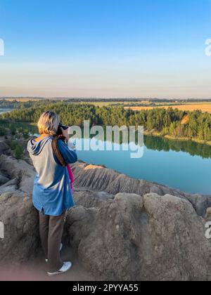 une fille touristique tient dans les mains prendre la photographie cliquez sur un appareil photo moderne Banque D'Images