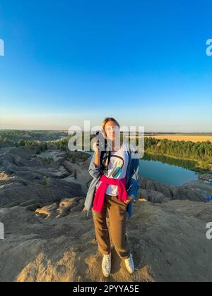 une fille touristique tient dans les mains prendre la photographie cliquez sur un appareil photo moderne Banque D'Images