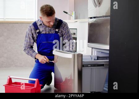 Électricien technicien travaillant à la réparation d'un réfrigérateur ou d'un appareil de réfrigération Banque D'Images