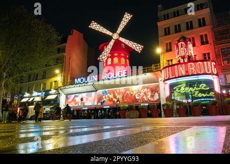 Paris - 24 avril 2023 : l'extérieur du Moulin Rouge la nuit à Paris, France. Le Moulin Rouge est le lieu de cabaret le plus célèbre de France Banque D'Images