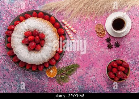 vue de dessus savoureux tarte aux fraises avec une tasse de thé sur fond rose tarte au thé biscuit gâteau sucre biscuits sucré Banque D'Images