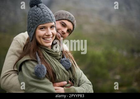 Ils adorent profiter de la vue sur la montagne. Un jeune couple heureux qui profite des sites touristiques tout en faisant de la randonnée dans la montagne. Banque D'Images