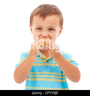 Inculquer de bonnes habitudes alimentaires. Un jeune garçon mignon mangeant une tranche d'orange isolée sur blanc. Banque D'Images