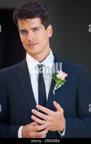 Désolé Mesdames, Hes pris. Portrait d'un jeune marié beau sourire à vous et ajuster l'anneau sur son doigt. Banque D'Images