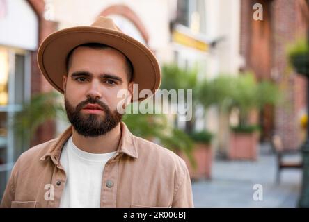 Portrait d'un beau barbu en chapeau sur la rue de la ville. Espace pour le texte Banque D'Images