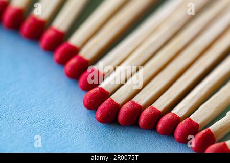 gros plan d'une rangée de matchsticks à tête rouge alignés sur le bleu Banque D'Images