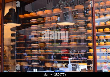 Amsterdam, pays-Bas - 25 juin 2022: De nombreuses roues de fromage sur les étagères, vue par fenêtre de verre Banque D'Images