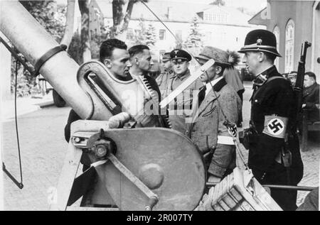 Un policier de Sudeten. En uniforme avec le brassard de la swastika, avec des soldats allemands au poste-frontière de Sebnitz après l'annexion des Sudètes. Après l'annexion de l'Autriche, Hitler a exigé qu'il soit donné la région des Sudètes en Tchécoslovaquie. Lors de la conférence de Munich en septembre 1938, les puissances occidentales ont accepté cela et les nazis ont occupé la zone. Peu de temps après, Hitler a rompu sa promesse et a envahi le reste de la Tchécoslovaquie avant de tourner son attention vers la Pologne. Bundesarchiv, Bild 146-1978-001-05 / CC-BY-sa 3,0 Banque D'Images