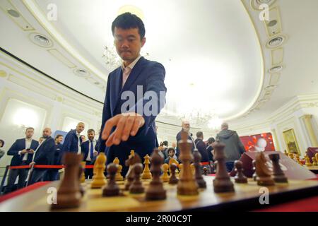(230506) -- BUCAREST, 6 mai 2023 (Xinhua) -- la championne d'échecs du monde Ding Liren (haut) de Chine fait un mouvement lors d'un jeu d'échecs simultané contre des challengers lors de la cérémonie d'ouverture officielle du Grand Chess Tour 2023 à Bucarest, Roumanie, 5 mai 2023. (Photos de Cristian Cristel/Xinhua) Banque D'Images