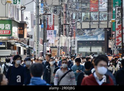 La rue de magasins et de restaurants très fréquentés est pleine de gens avec des masques, de la publicité et des magasins près de la gare dans la ville de Sendai, dans le nord du Japon Banque D'Images