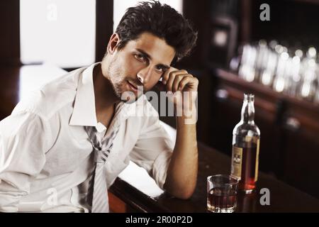 Homme d'affaires, boire et portrait en happy hour dans un bar avec alcool et whisky après le travail. Bouteille, homme et visage dans un restaurant avec un Banque D'Images