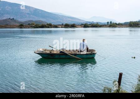 Butrint, Albanie - 16 septembre 2021: Un pêcheur albanais dans son bateau sur le lac de Butrint lagon salé, vue du parc national de Butrint, la célèbre UNES Banque D'Images