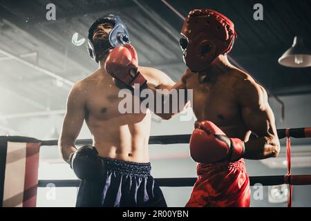 Boxer utiliser différentes combinaisons de poinçons, y compris le jab, crochet, coupe supérieure, croix, rotation, droite. Se rapprocher pour faire un adversaire sur les cordes et le knopo Banque D'Images