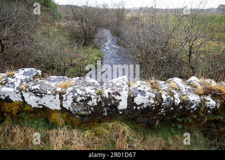 ancien pont en pierre sur le petit ruisseau en crue dans la région rurale éloignée de montagne du comté de donegal république d'irlande Banque D'Images