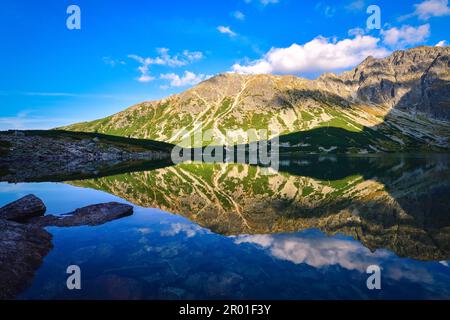 Magnifique paysage de montagne d'été au bord du lac. Vue sur les montagnes se reflétant dans l'eau à Czarny Staw Gasienicowy dans les Hautes Tatras de Pologne. Banque D'Images