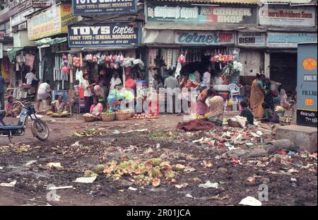 Une rue de marché avec des magasins et des gens dans le centre-ville de Mumbai en Inde. Inde, Mumbai, mars 1998 Banque D'Images