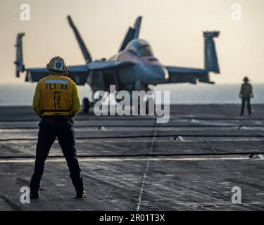 USS Nimitz, eaux internationales. 01 mai 2023. A ÉTATS-UNIS Le marin de l'équipage du pont de vol de la Marine surveille un avion de chasse F/A-18F Super Hornet du Mighty Shrikes of Strike Fighter Squadron 94, un taxi sur le pont de vol du porte-avions de la classe Nimitz USS Nimitz en cours d'exécution des opérations de routine, 1 mai 2023 en mer de Chine méridionale. Crédit : MC2 Justin McTaggart/U.S. Navy photo/Alay Live News Banque D'Images