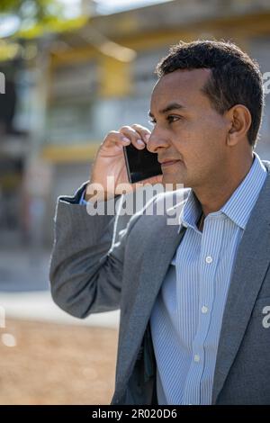 Photo moyenne d'un jeune latino parlant au téléphone. Banque D'Images