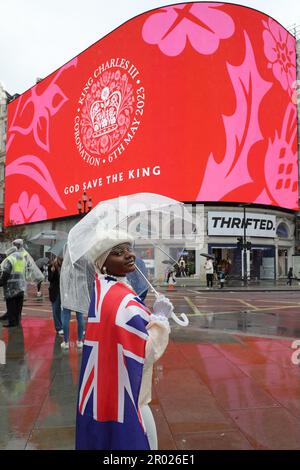 Londres, Royaume-Uni. 6th mai 2023. Supporter portant le drapeau rouge, blanc et bleu de Union Jack regardant le message de Coronation pour le couronnement du roi Charles III, à Piccadilly Circus, Londres dire heureux et glorieux et Dieu sauver le roi crédit: Paul Brown/Alay Live News Banque D'Images