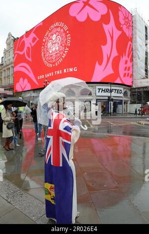 Londres, Royaume-Uni. 6th mai 2023. Supporter portant le drapeau rouge, blanc et bleu de Union Jack regardant le message de Coronation pour le couronnement du roi Charles III, à Piccadilly Circus, Londres dire heureux et glorieux et Dieu sauver le roi crédit: Paul Brown/Alay Live News Banque D'Images