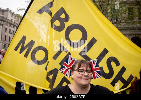 Un royaliste se tient devant une bannière tenue par des membres du groupe anti-monarchiste 'Republic' à Trafalgar Square le jour du couronnement du roi Charles III, le 6th mai 2023, à Londres, en Angleterre. Selon la police met, ils ont été retenus pour violation de la paix, conspiration pour causer des nuisances publiques et possessing d'articles pour causer des dommages criminels. Banque D'Images