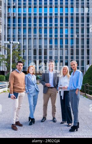 Portrait d'un groupe joyeux de collègues marchant à l'extérieur dans un bureau d'entreprise Banque D'Images