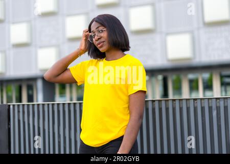 City Slicker : un modèle noir tendance respire la confiance et le style dans la jungle urbaine Banque D'Images