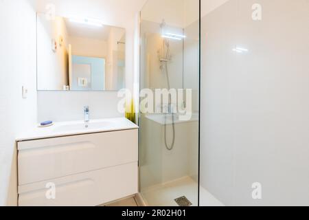 Maison salle de bains, nouvelle salle de bains lumineuse intérieur avec douche en verre, meuble-lavabo, intérieur conçu en bois blanc Banque D'Images