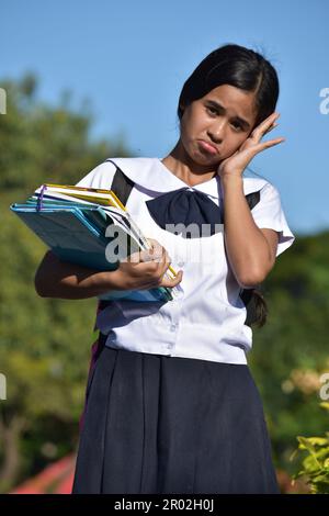 Adorable petite fille étudiante et anxiété avec des livres Banque D'Images