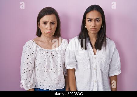 Mère hispanique et fille ensemble sceptique et nerveux, frowning bouleversé à cause du problème. personne négative. Banque D'Images