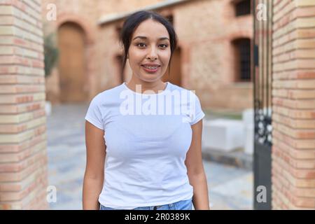 Jeune femme arabe souriant confiante dans la rue Banque D'Images