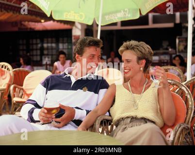 Espagne. Marbella. Jeune couple assis dans un café-bar extérieur. Banque D'Images