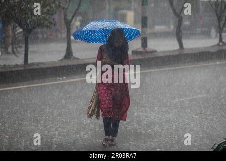 Dhaka, Bangladesh. 6th mai 2023. Une femme tient un parapluie tout en marchant le long de la rue un jour de pluie. La forte baisse de la mousson a rendu les déplacements lents et dangereux. (Credit image: © Sazzad Hossain/SOPA Images via ZUMA Press Wire) USAGE ÉDITORIAL SEULEMENT! Non destiné À un usage commercial ! Crédit : ZUMA Press, Inc./Alay Live News Banque D'Images