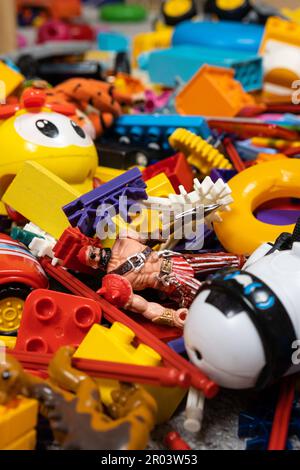 Une abondance de jouets dans la chambre des enfants, beaucoup de pièces en plastique multicolores de designers, pièces de rechange pour jouets, figurines et cubes. Banque D'Images