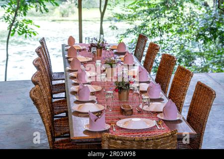 Table et chaises en rotin servies sur une terrasse de restaurant vide. Tanzanie, Afrique de l'est Banque D'Images