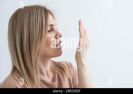 une fille sérieuse vérifie son souffle de bouche Banque D'Images