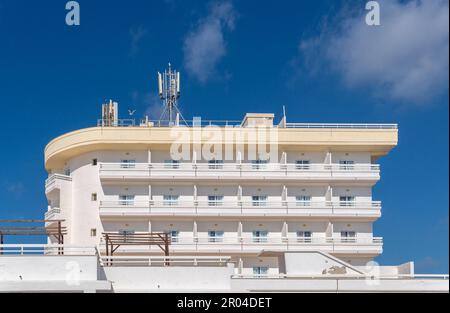 Façade d'un hôtel touristique blanc fermé dans la ville Majorcan de Portocolom, Espagne Banque D'Images