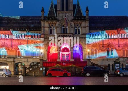 6 mai 2023. Winchester, Hampshire, Angleterre, Royaume-Uni. Dans la soirée du couronnement du roi Charles III et de la reine Camilla, le Guildhall du centre-ville de Winchester a été illuminé avec des projections de la vie du roi et des symboles du couronnement pour célébrer l'occasion. Banque D'Images