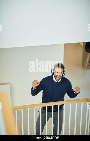 HES sentir la rainure. un jeune homme d'affaires qui écoute de la musique dans un bureau. Banque D'Images